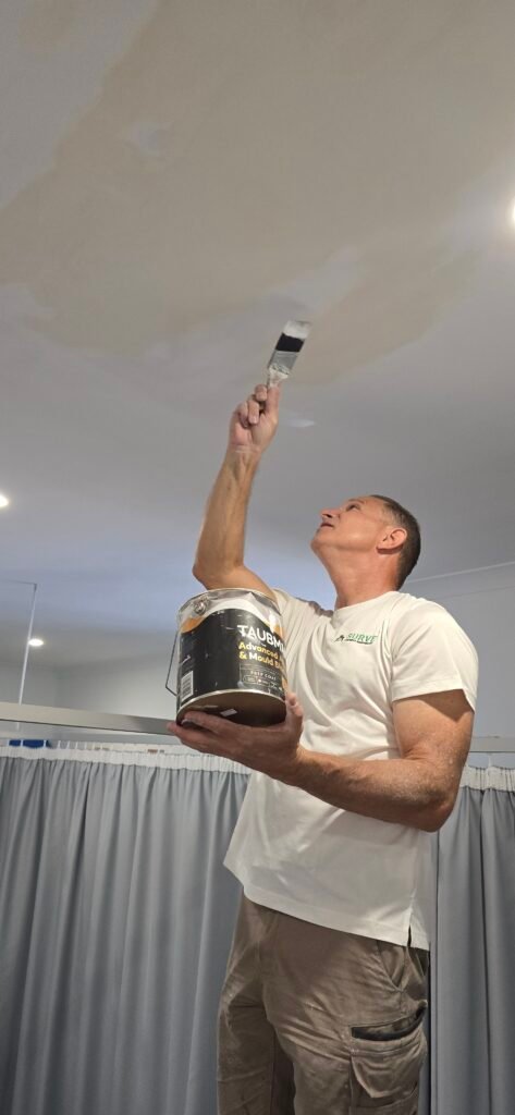 Handyman painting a ceiling