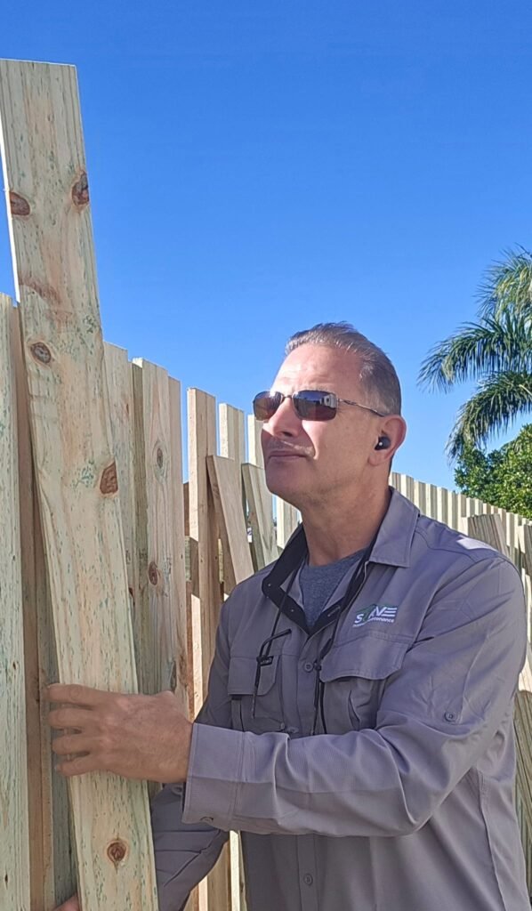 Handyman installing timber paling fence boards