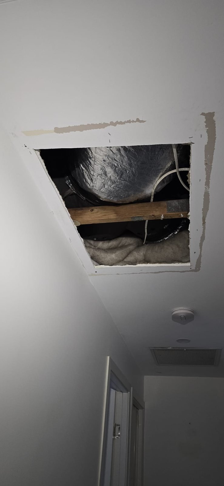 Before: hallway ceiling cut open to remove water-damaged plasterboard