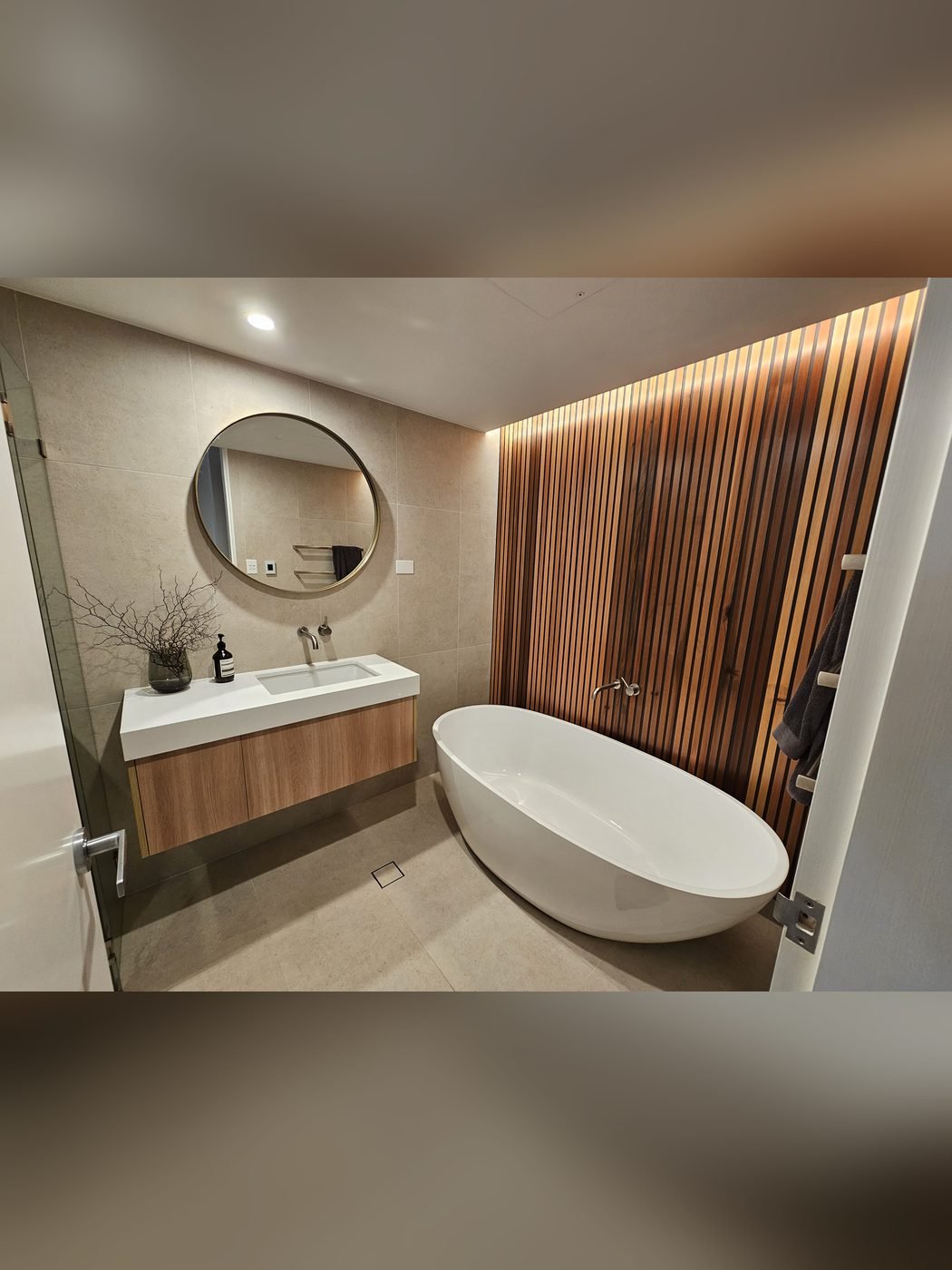 After: bathroom renovation with freestanding bath and timber slat wall by SURVE
