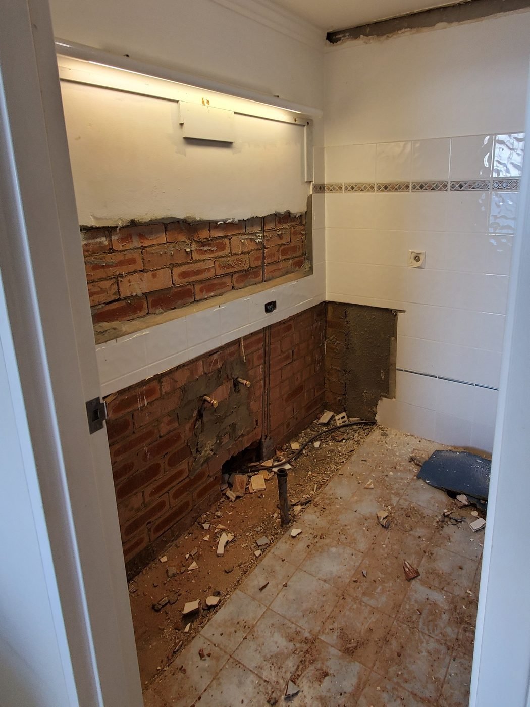 Before: bathroom vanity wall stripped back to brick