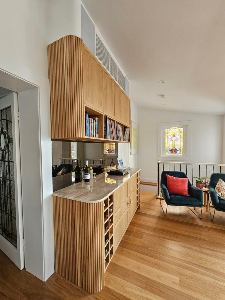 Custom fluted timber cabinetry and shelving in a renovated living area