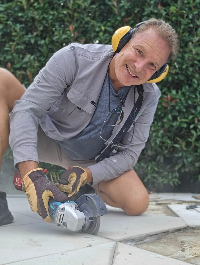 Handyman cutting pavers with an angle grinder