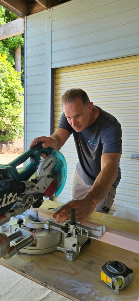 Handyman cutting timber with a mitre saw