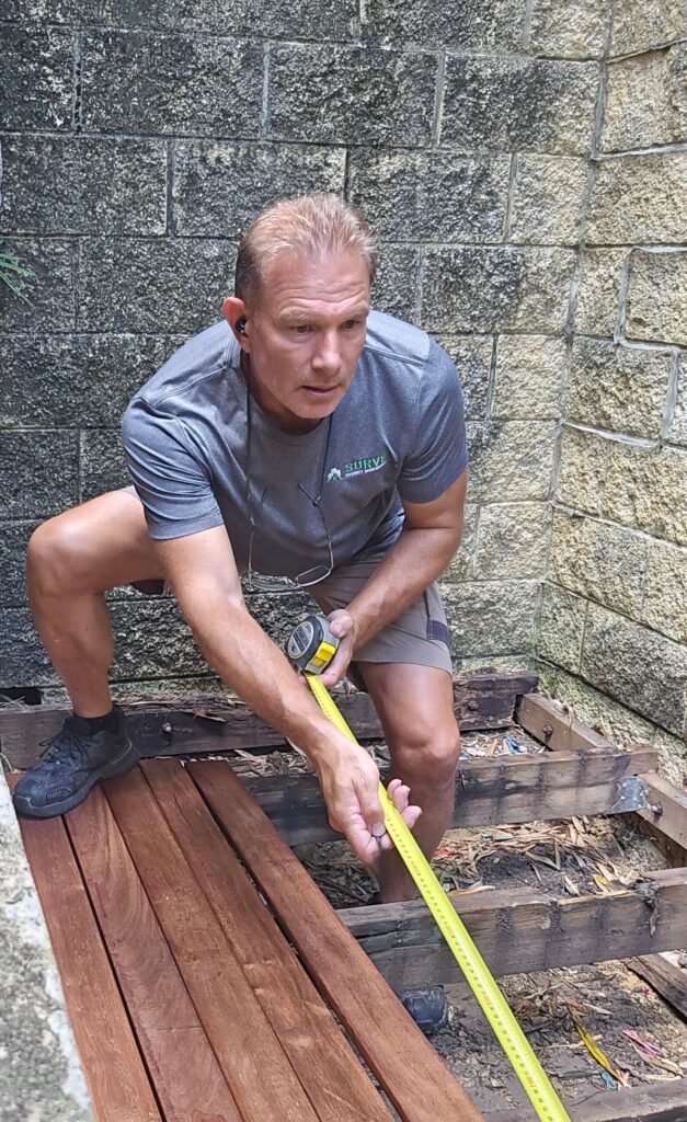 Handyman measuring timber for a deck repair