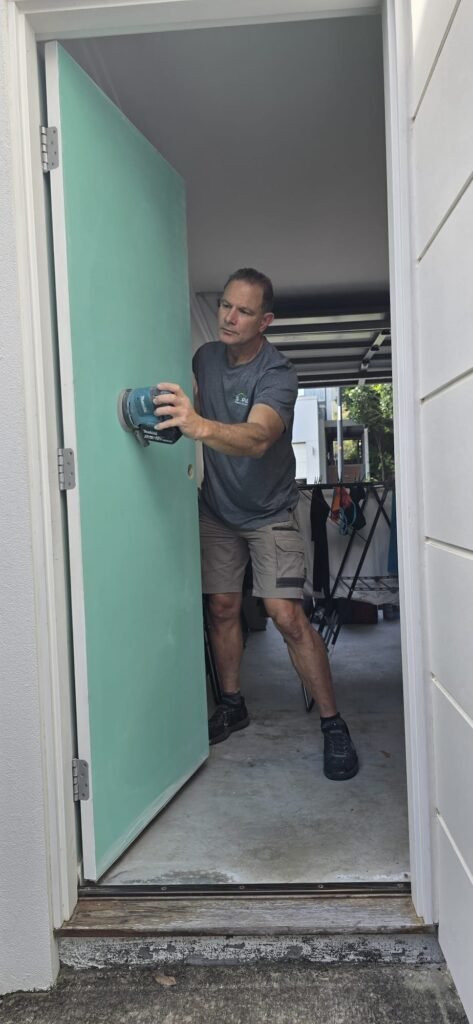 Handyman sanding a new internal door